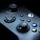 An Xbox Series X controller lays on a table in a dark room.
